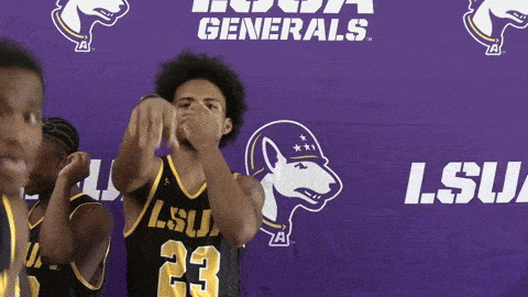 a man in a lsu jersey stands in front of a purple banner