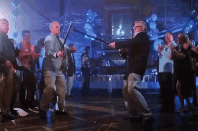 a man in a suit is holding a bat while dancing