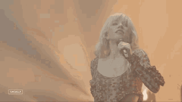 a woman singing into a microphone with the word cancella on the bottom