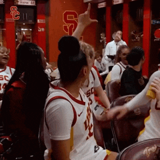 a group of basketball players are sitting in a locker room with the letters ucs on the wall