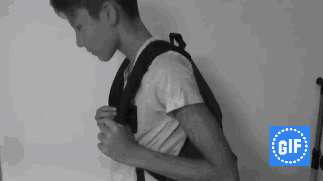 a boy with a backpack is standing in front of a gif