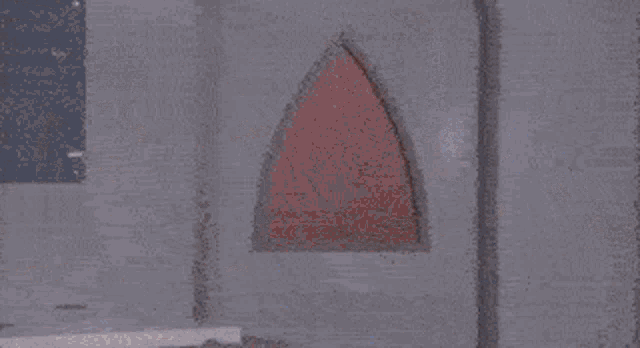 a man in a red costume is standing in a room with a woman behind him and says desculpa pela demora .