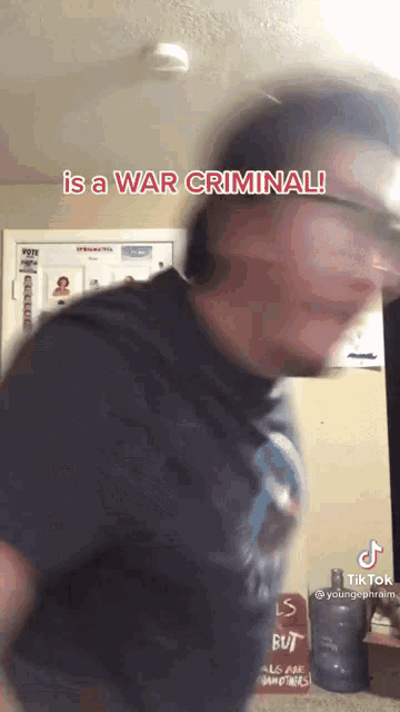 a blurry picture of a man with the words is a war criminal