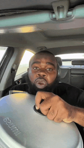 a man is sitting in a car holding a container that says ' wurst ' on it