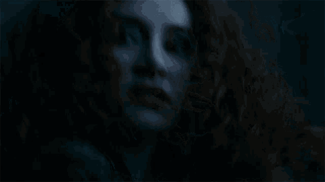 a close up of a woman with red curly hair