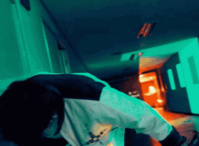 a person in a hallway with a green light on