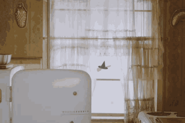 a westinghouse refrigerator sits in a kitchen near a window