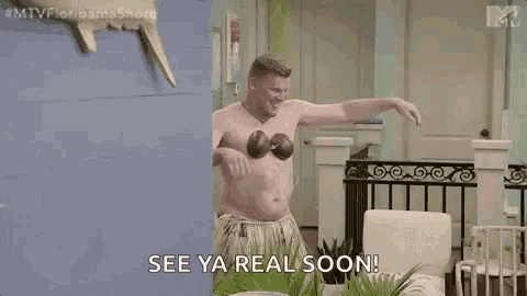 a shirtless man is dancing in a living room while holding a coconut in his hand .