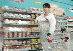 a man is pushing a shopping cart in a supermarket