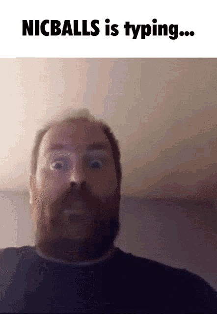 a man with a beard is looking at the camera with the words nicballs is typing