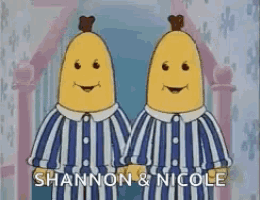 two bananas are standing next to each other wearing pajamas and smiling .