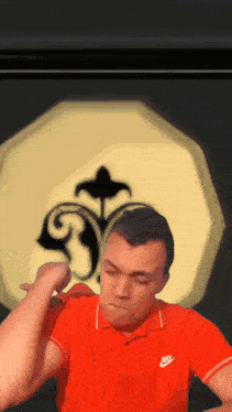 a man wearing a red nike shirt is making a face