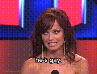 a woman is standing in front of a microphone and says he 's gay .