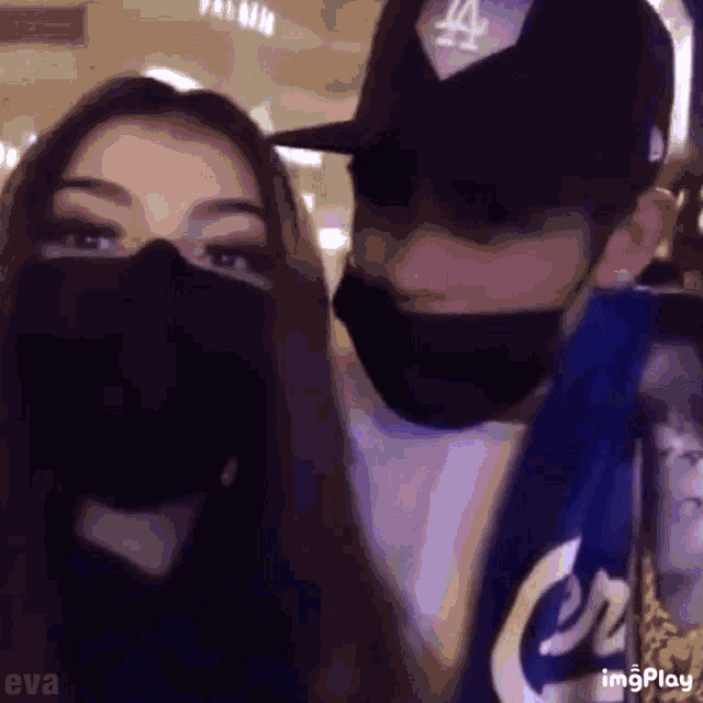 a man and a woman are wearing masks and hats .