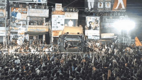 a large crowd of people are gathered in front of a building that says subha gruha