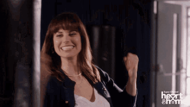 a woman is dancing in front of a super channel logo