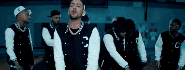 a group of men are wearing varsity jackets with the letter c on the sleeves