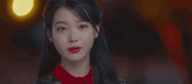 a close up of a woman 's face with red lipstick and earrings .