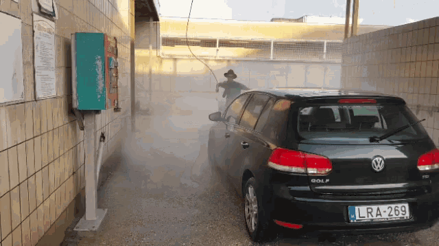 a man is washing a black volkswagen golf