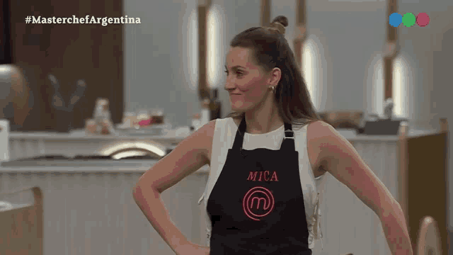 a woman wearing a black apron with mica written on it