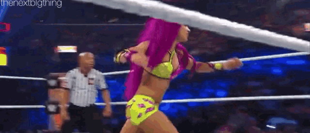 two women are wrestling in a wrestling ring with a referee watching .