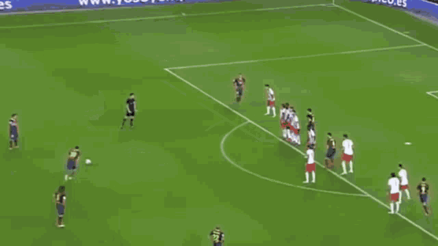 a soccer goalie is diving to catch a soccer ball in front of a qatar airways sign