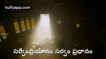 a person is laying in a dark room with a light coming out of the door .