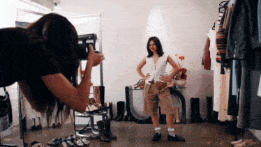 a woman is taking a picture of another woman in a clothes store