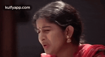 a woman in a red dress is holding her head in pain .