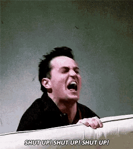 a man is screaming with his mouth open while holding onto a railing .