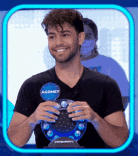 a man wearing a black shirt with agoney written on it
