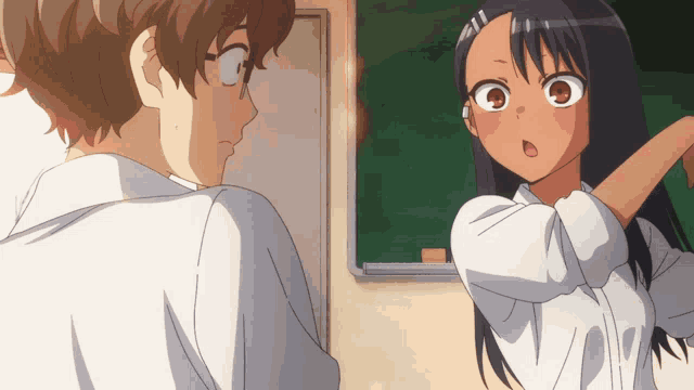 a boy and a girl standing in front of a blackboard