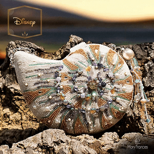 a purse made by disney is sitting on some rocks