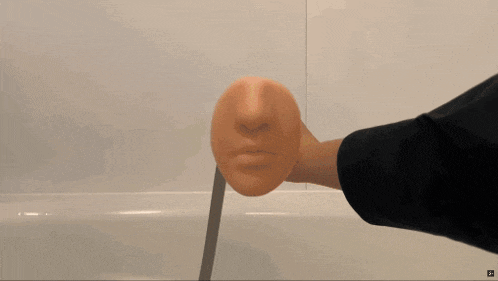 a person is spraying water from a shower head with a towel hanging on the wall