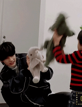 a man and a child are playing with stuffed animals in a living room .