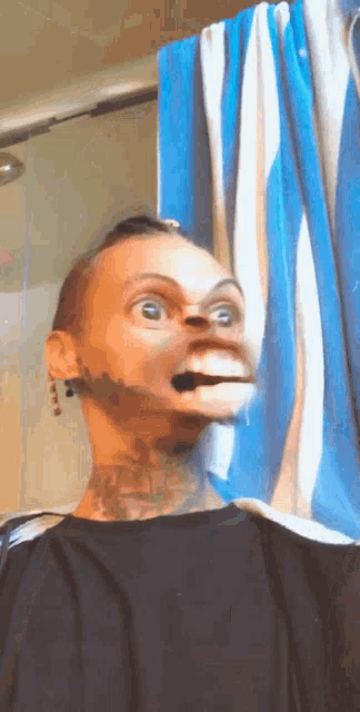 a man with a tattoo on his neck is making a funny face in front of a shower curtain
