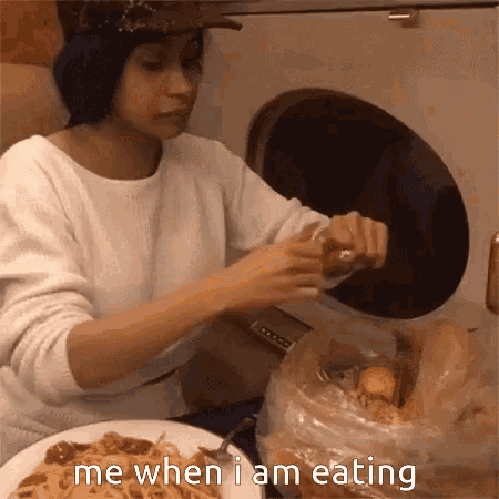 a woman is sitting at a table with a plate of food and the words `` me when i am eating ''