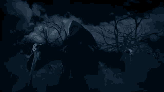 a silhouette of a person in a dark room with a tree in the background