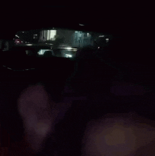 a woman is sitting in the back seat of a car at night .