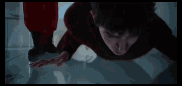 a man in a red sweater is laying on the ground