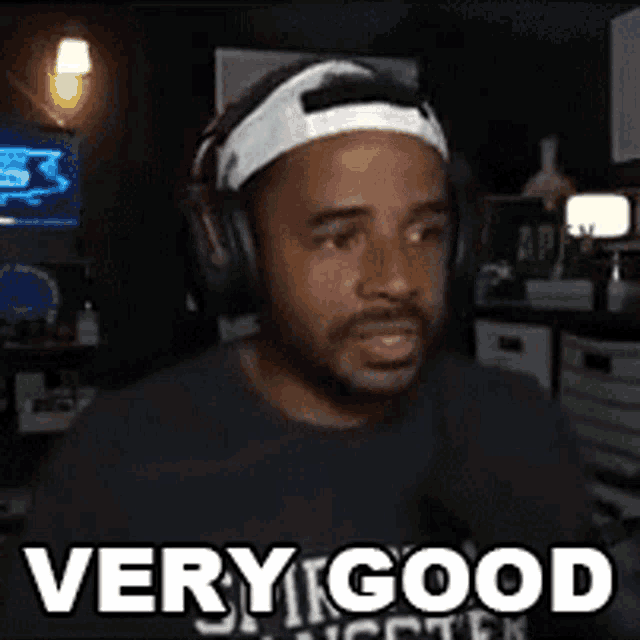 a man wearing headphones and a headband is sitting in a dark room .