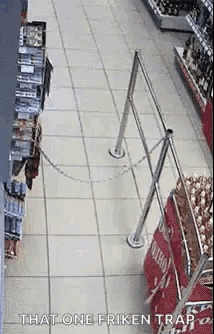 a person is chained to a railing in a store and walking down a aisle .
