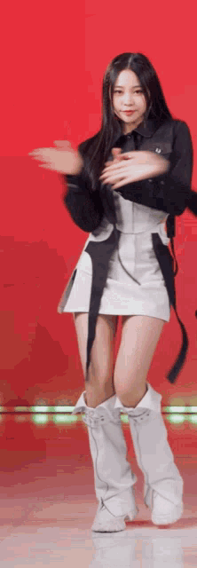 a woman in a white skirt and white boots is dancing on a stage
