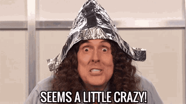 a man wearing a tin foil hat with the words seems a little crazy