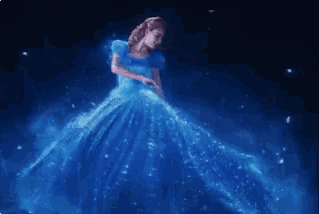 a woman in a blue dress dancing in the dark