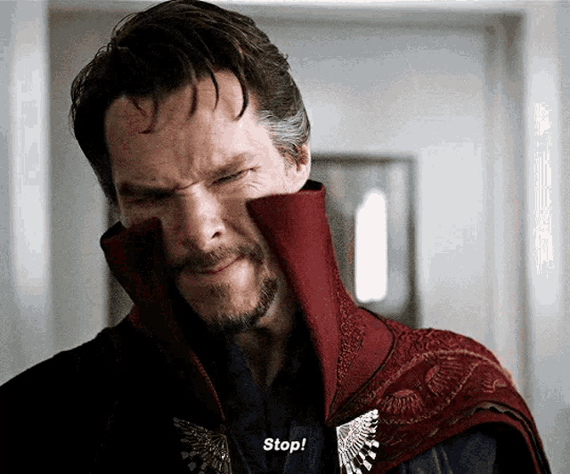 a man with a beard is wearing a red cape and says stop