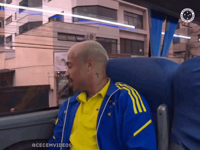 a man wearing a blue and yellow jacket is sitting on a bus with the hashtag @cecemvideos
