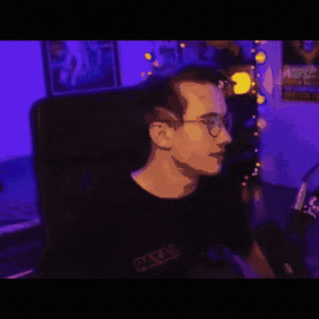 a pixelated image of a man wearing glasses and a black shirt
