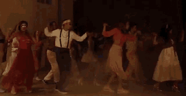a group of people are dancing in a dark room in a club .