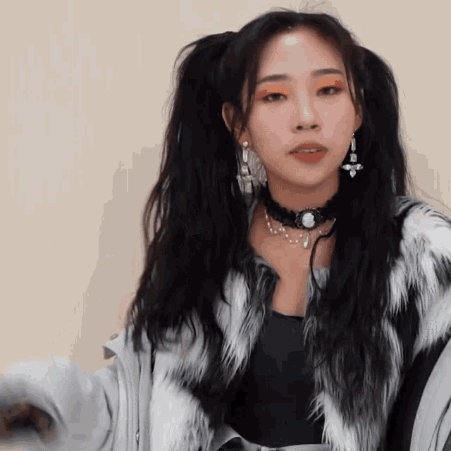 a woman wearing a fur coat and earrings has pigtails in her hair